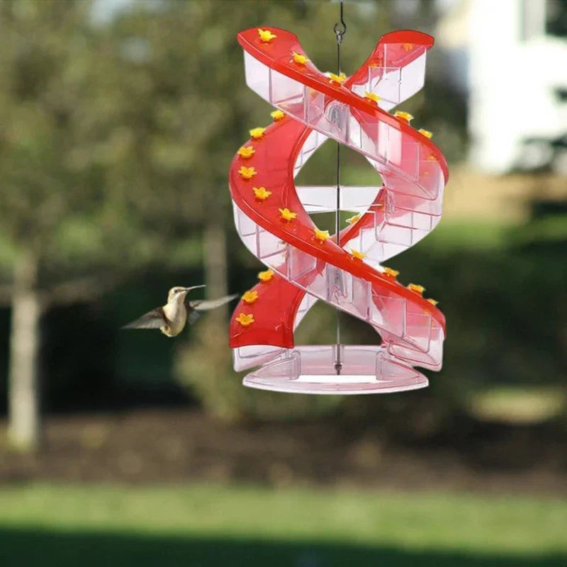 Hanging Bird Feeder - Spiral feeder hanging outdoors with a hummingbird approaching a feeding port