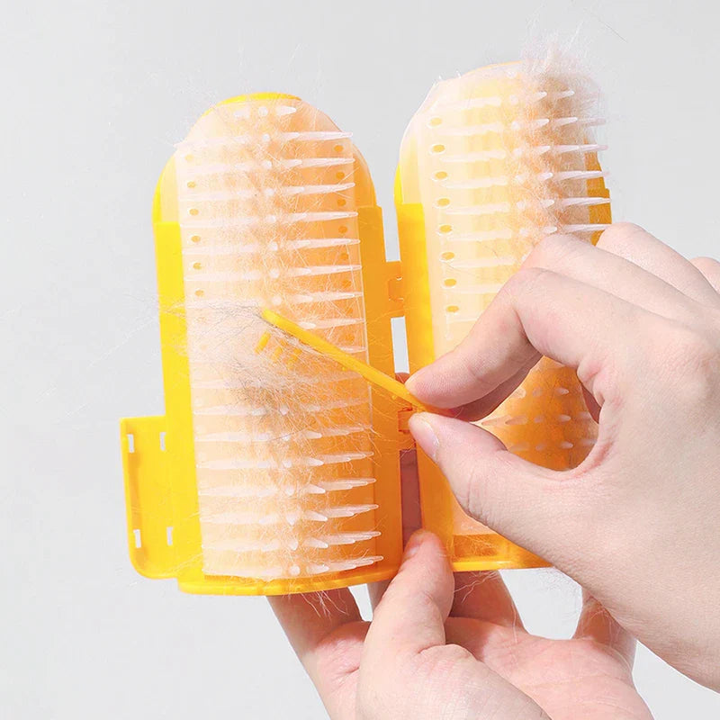 Pet Double Row Grooming Massager Brush - Hands open a used yellow double-sided grooming brush, clearing collected pet fur with a small yellow tool