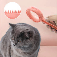 أداة العناية بالحيوانات الأليفة - يد تمسك بفرشاة تمشيط وردية مزدوجة الحلقة بالقرب من قطة رمادية، مع صورة مقربة مدمجة لأسنان الفرشاة المخروطية القصيرة