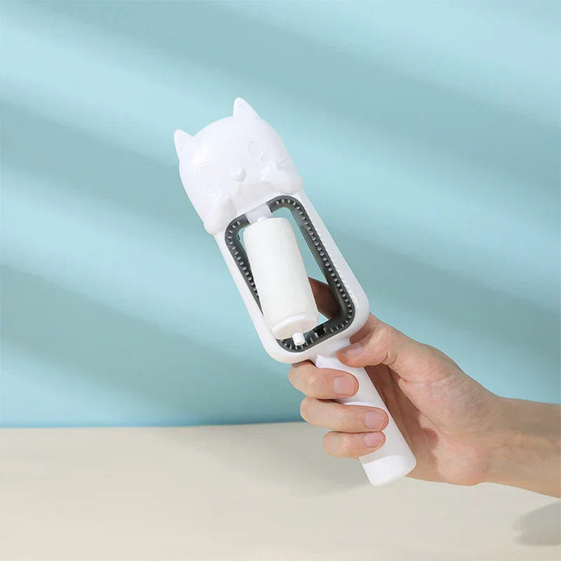 Pet Grooming Brush For Dogs - A hand holding a white cat-shaped pet grooming brush against a light blue and beige background