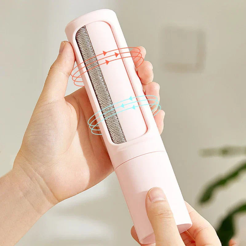 A hand holds an open pink pet hair remover brush, exposing its textured cleaning surface with red and blue directional arrows overlaid.