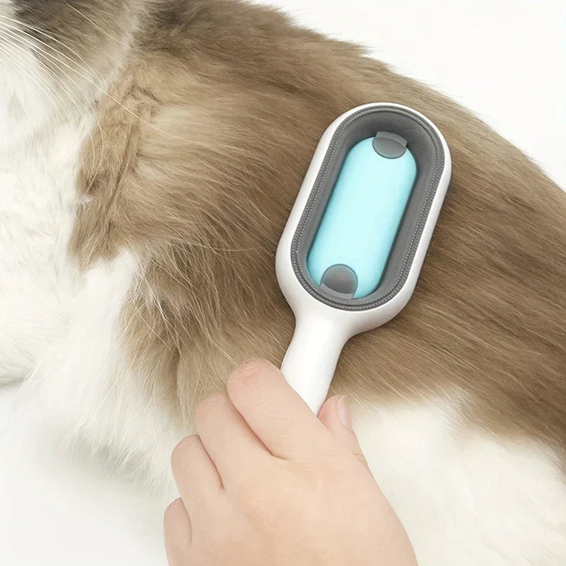 Hand holding a white pet hair remover brush while grooming a brown and white long-haired cat