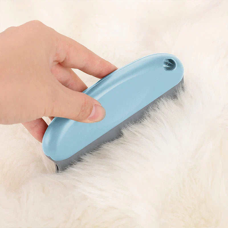 Hand holds light blue dog grooming comb brushing white fluffy fur
