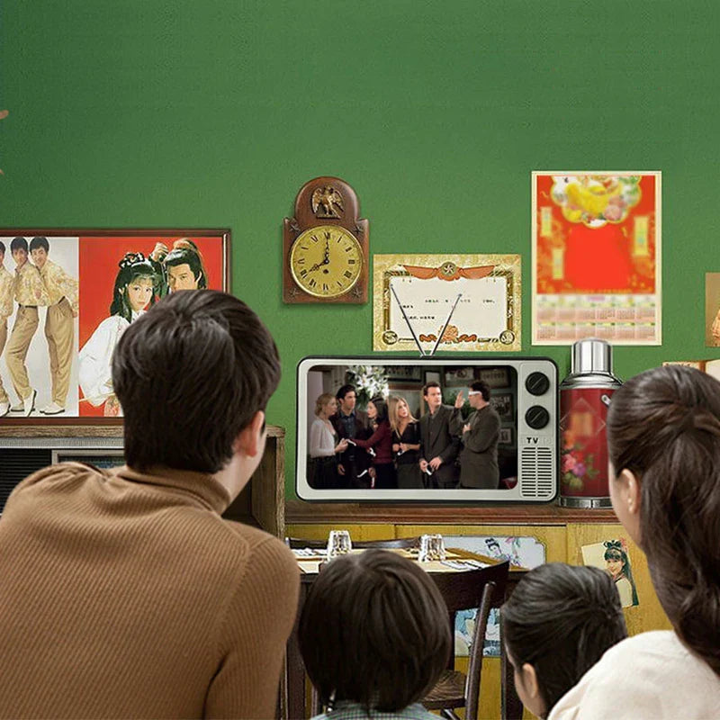 Family watching video on a retro TV-shaped phone screen magnifier in a vintage-decorated green room with wall posters and clock