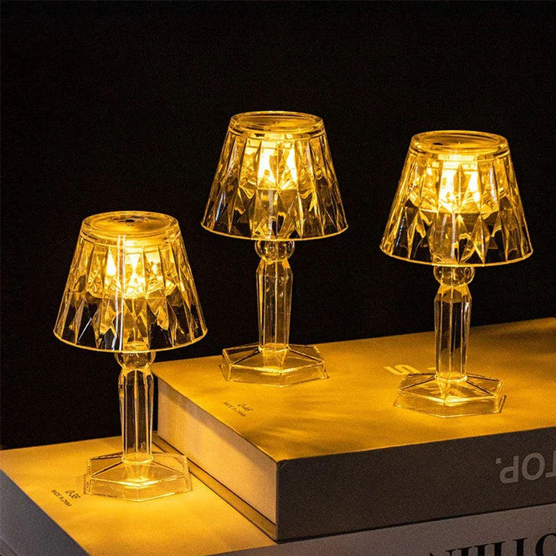 Three lit warm yellow mini led candle lamps placed on stacked books against dark background