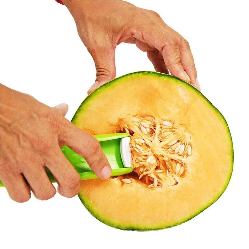 Hand holding green plastic melon slicer pressed against seeded center of a halved cantaloupe