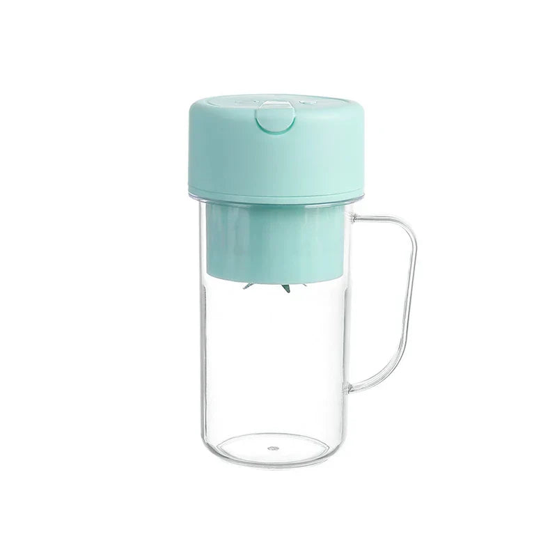 A mint green juicer cup with a clear plastic body, side handle, and a lid assembly with visible blending blades.