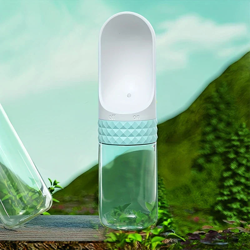 Dispensador de agua portátil con agarre texturizado azul claro sobre una superficie de madera con fondo natural verde