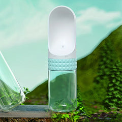 Dispensador de agua portátil con agarre texturizado azul claro sobre una superficie de madera con fondo natural verde