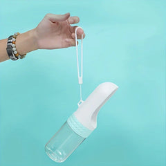 Una mano sostiene la correa de un dispensador de agua portátil con cuerpo blanco y transparente sobre un fondo azul claro sólido