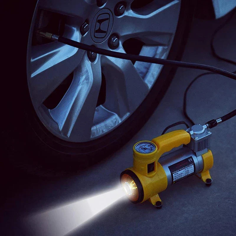 Honda car tire connected by hose to yellow electric air pump emitting light in a dark setting