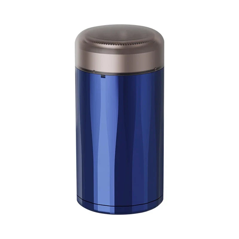 Dark blue cylindrical mini electric shaver standing upright with brown protective cap, on white background