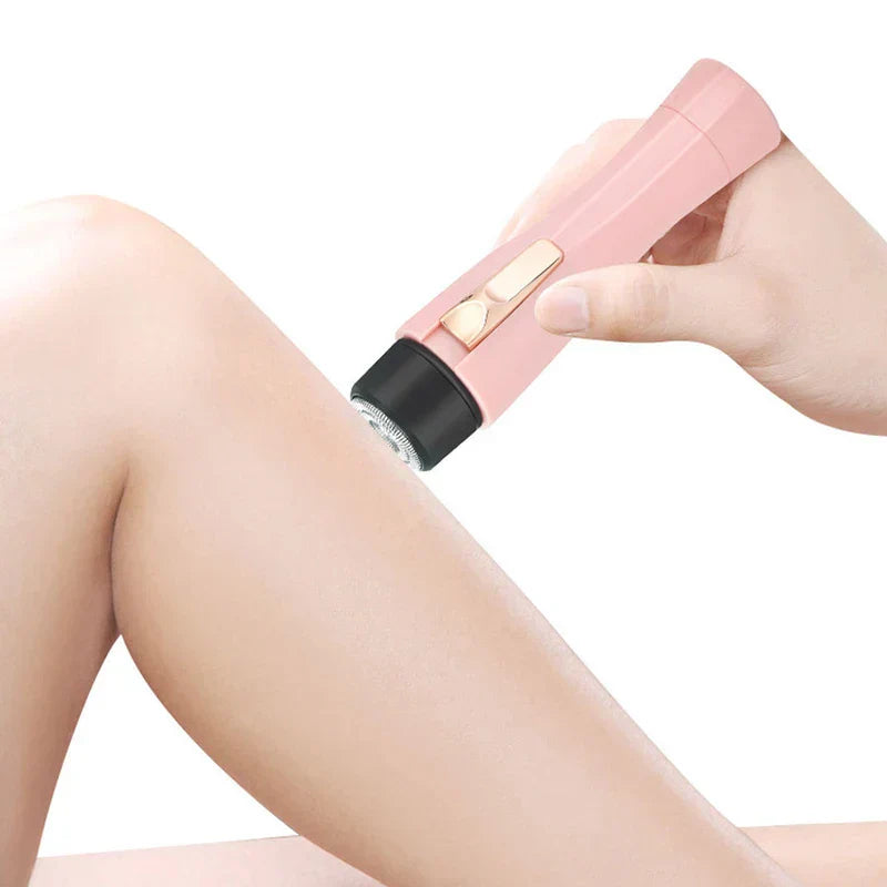 Hand using pink electric hair shaver to remove hair on leg