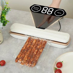 White and gold bag sealing tool with digital display, sealing a plastic bag holding cured sausages on a countertop
