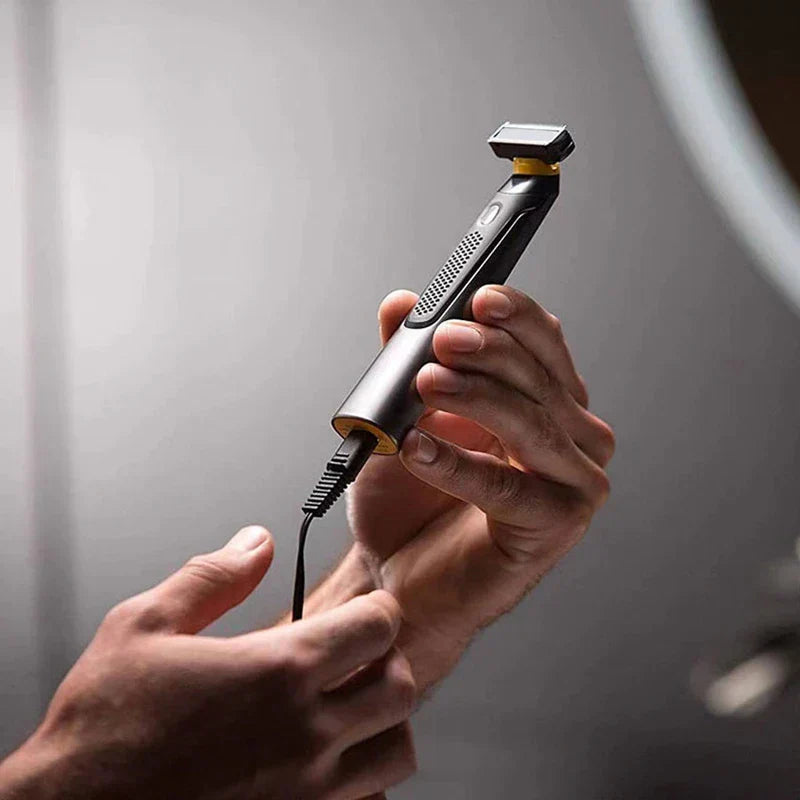 Hand plugging charging cable into cordless electric body hair trimmer for men