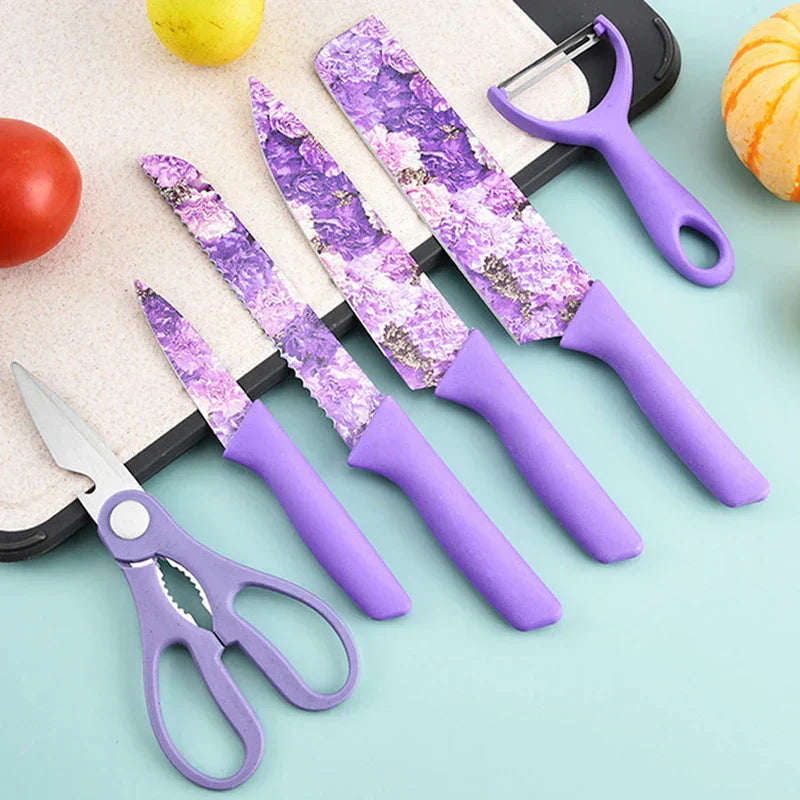 6 piece kitchen utensil set with purple floral design on light blue surface near tomato, lemon, and small pumpkin
