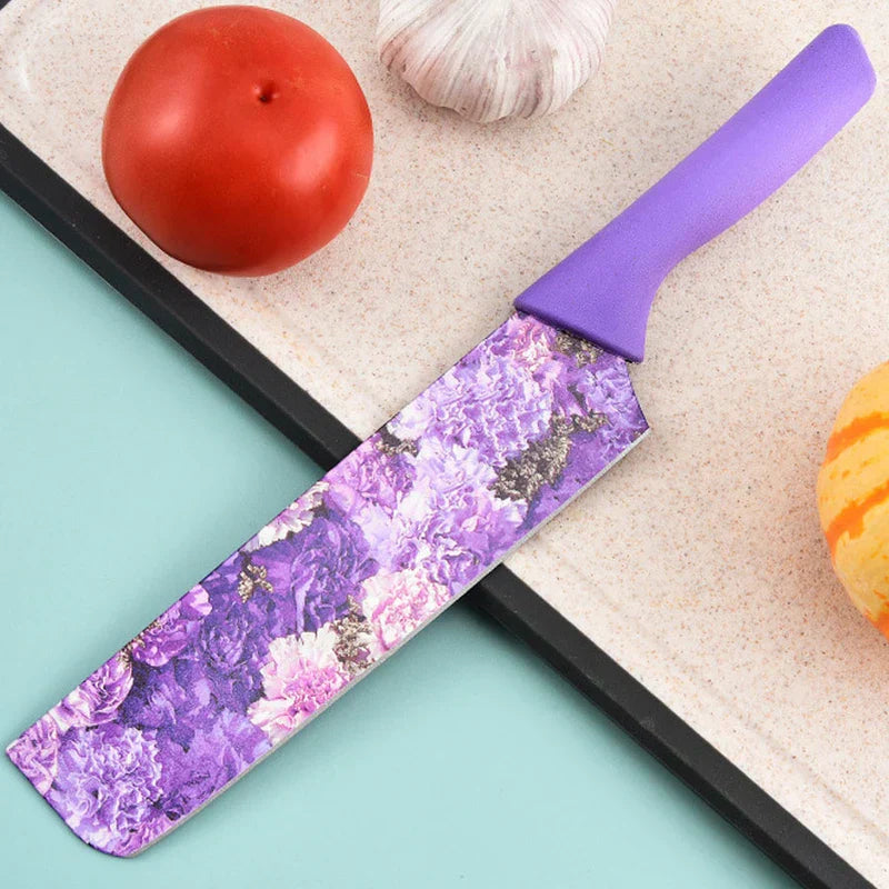 Purple floral nakiri knife on a cutting board with tomato, garlic, and squash, part of a 6 piece kitchen utensil set