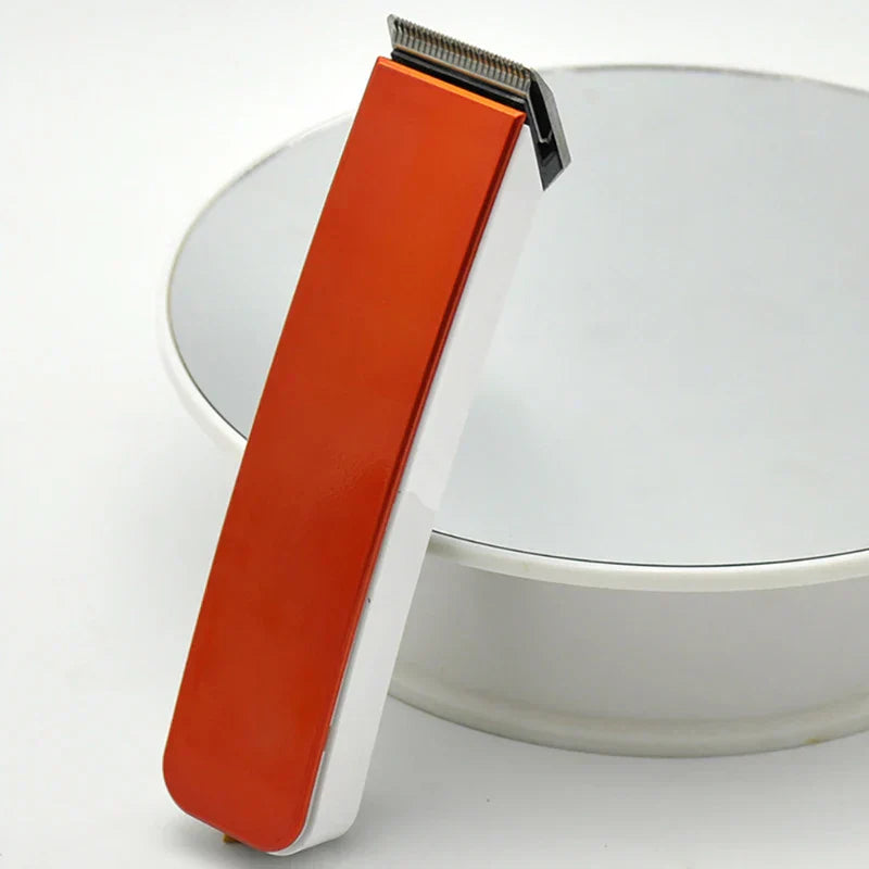 Orange and white hair clipper trimmer leaning against a white round display stand on a white surface