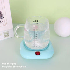 Glass protein shaker bottle with liquid sits on a light blue USB charging magnetic stirring base on a light green table