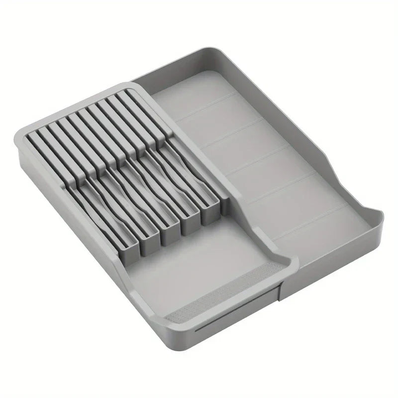 bloque de cuchillos - Organizador gris para cuchillos de cocina con secciones ranuradas para cuchillos y un compartimento abierto para utensilios, vacío.