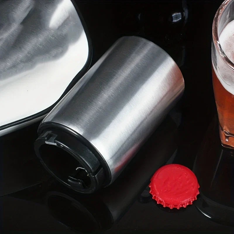 Stainless steel beer bottle opener lying on black surface next to red bottle cap and glass of beer