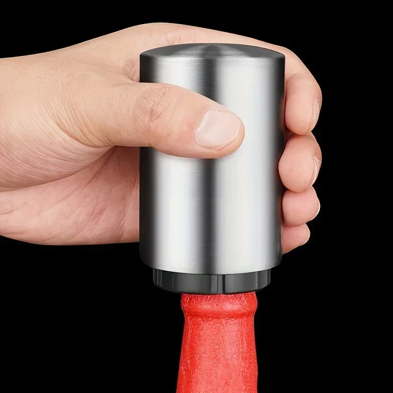 Hand gripping stainless steel beer bottle opener placed over a red beer bottle neck against black background