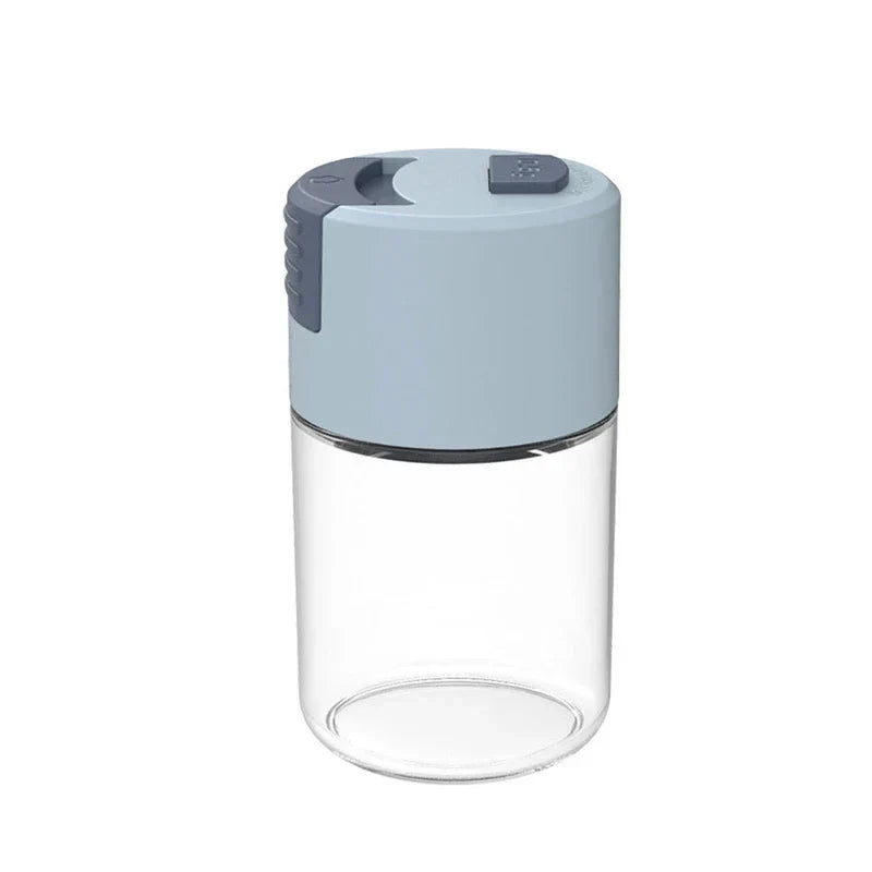 Light blue and dark gray topped salt shaker bottle with clear glass body on white background