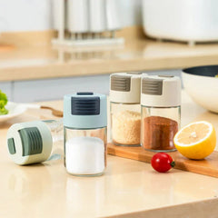 Salt Shaker Bottle - Salt shaker bottles in light blue, white, and light green, with various spices, on a beige kitchen counter