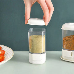 Hand opening lid of clear plastic spice jar with fine seasoning powder inside