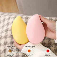 Rechargeable Hand Warmer - Hands hold yellow and pink mango-shaped rechargeable hand warmers, with a 3-heat-level indicator below
