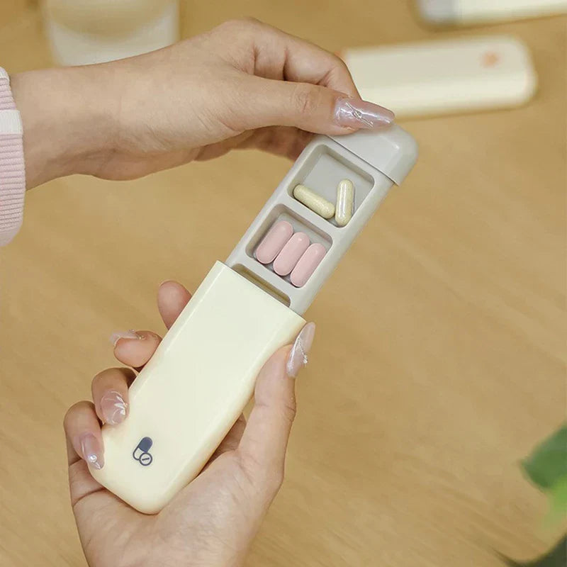 Hands pulling open a beige weekly pill organizer to show two internal compartments holding pills