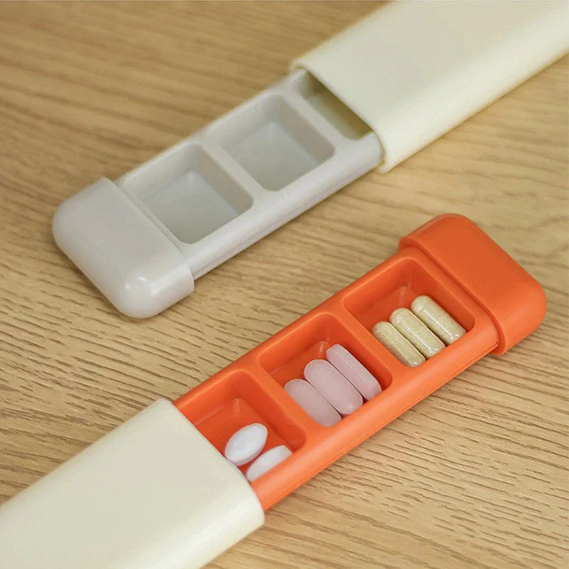 Weekly Pill Organizer - Two opened weekly pill organizers on a wood surface, one with gray compartments and one with orange compartments holding assorted pills