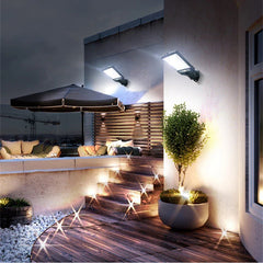 Rooftop patio at dusk with wall-mounted outdoor light bulb fixtures, wooden steps, and lounge seating with umbrella