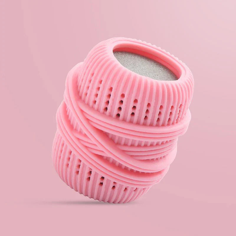Pink ribbed cleaning ball with porous top and banded detailing, set against a solid light pink background