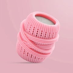 Pink ribbed cleaning ball with porous top and banded detailing, set against a solid light pink background