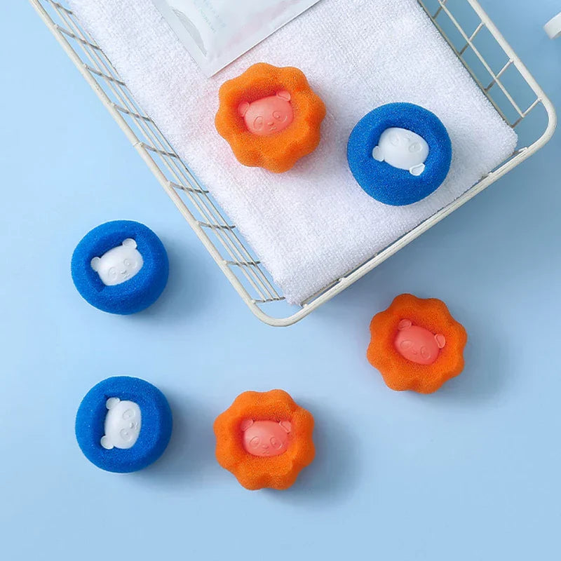 Seis artículos redondos esponjosos (azules y naranjas, cada uno con un inserto de panda) colocados sobre y alrededor de una toalla blanca en un estante de alambre; hay una bola de lavandería presente.