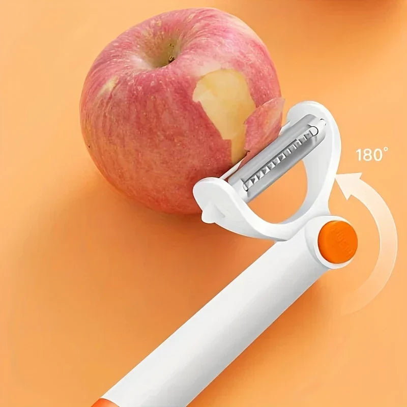 White and orange 180-degree swivel vegetable peeler peeling skin from a red apple on an orange surface.
