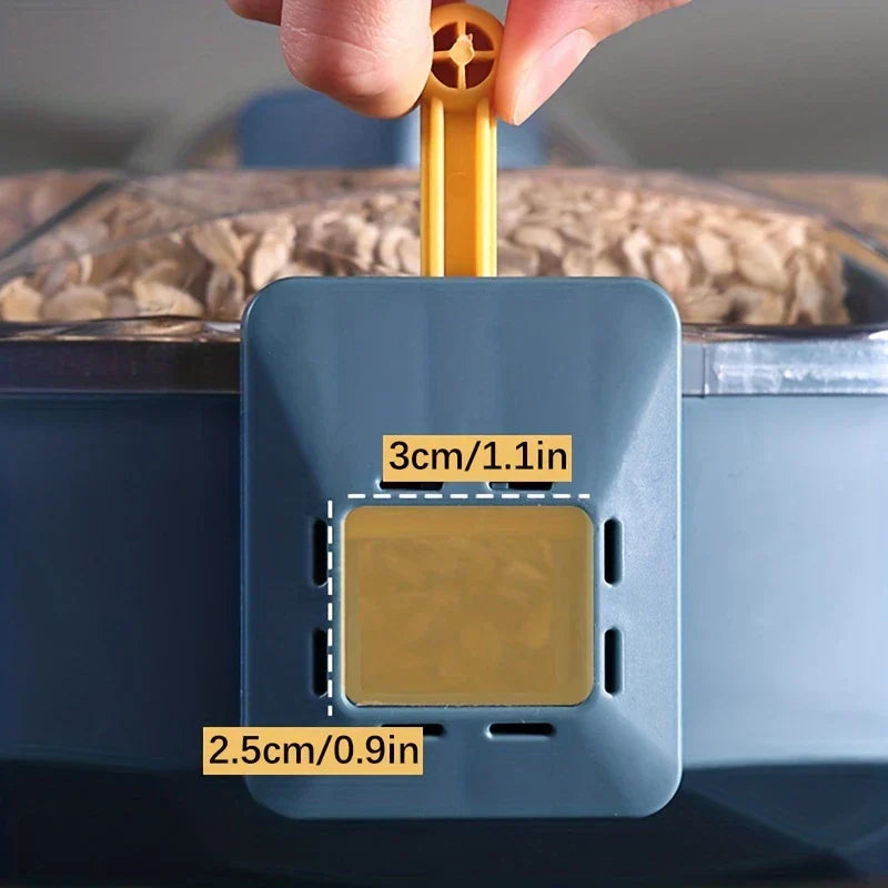 Fingers pulling a yellow tab on a blue rice dispenser lid, with grain visible behind, labeled with 3cm/1.1in and 2.5cm/0.9in dimensions