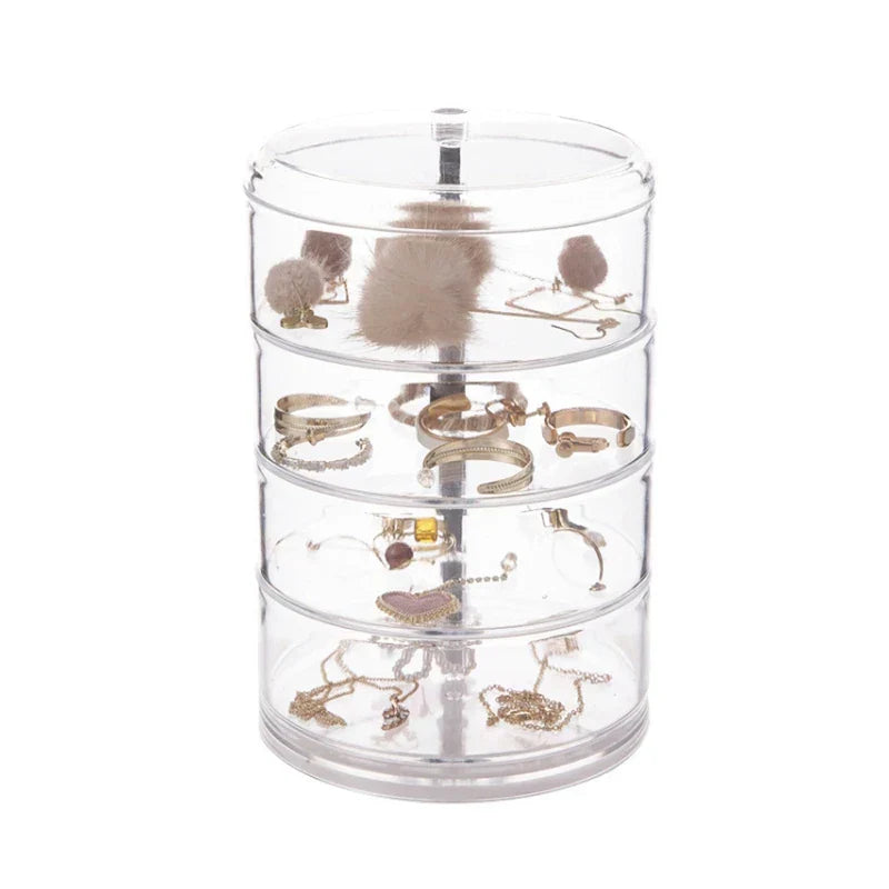 4-layer clear rotating jewelry organizer box holding earrings, rings, and necklaces.