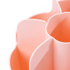 Close-up of a peach-colored petal-shaped compartment of a makeup brush holder, showing its curved edges and inner cavity