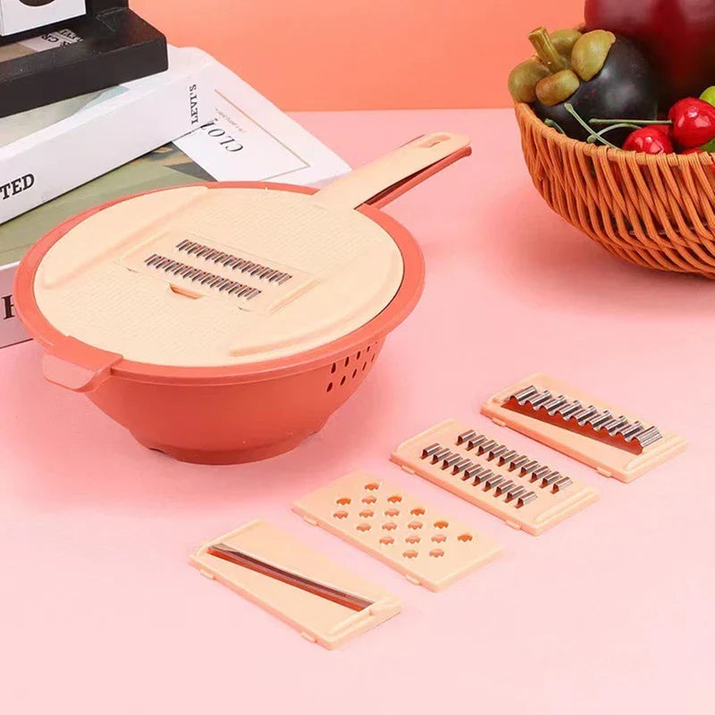 Pink vegetable slicer grater set with interchangeable blades, colander base, and fruit basket on pink background