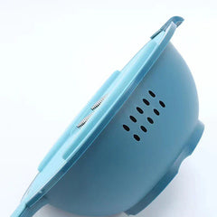 Close-up side view of a light blue vegetable slicer grater showing drainage holes and the top slicing surface