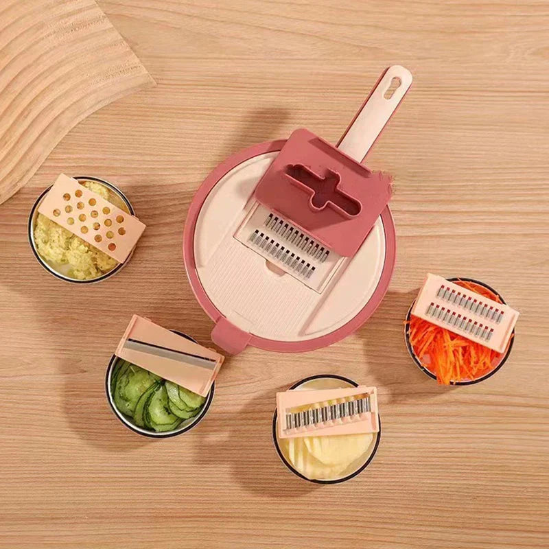 Top-down view of a pink vegetable slicer grater set with 4 interchangeable blades and prepared vegetable samples on wood