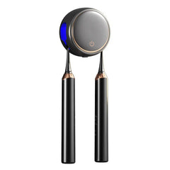 Black round wall-mounted toothbrush sanitizer holder with two black electric toothbrushes hanging from it, blue light on left side