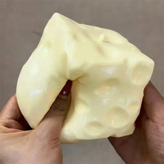 Jumbo cheese cube stress ball next to a keyboard