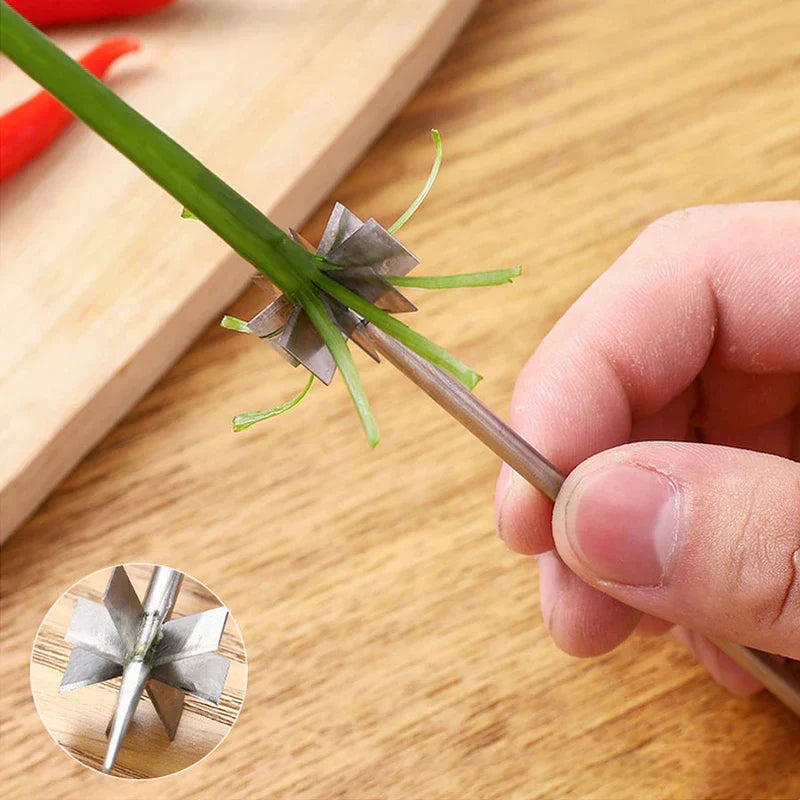 Hand holding scallion shredder cutter slicing a green scallion into thin strips on a wooden kitchen countertop