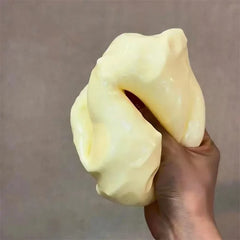 Jumbo Stress Ball - A hand squeezes a pale yellow soft cheese-shaped object, deforming it under pressure.