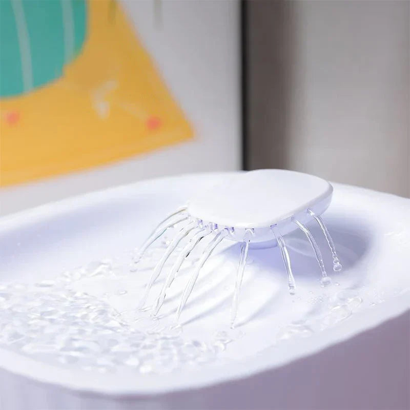 Close-up of pet water fountain top, showing multiple streams of water flowing out of the fountain’s top dispenser