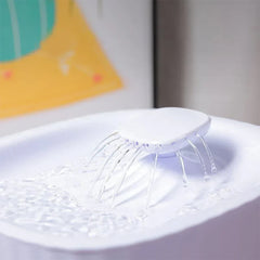 Close-up of pet water fountain top, showing multiple streams of water flowing out of the fountain’s top dispenser