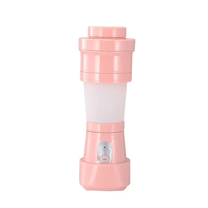 Rosa Smoothie-Maker für eine Portion mit halbtransparentem Mittelbecher und Bedienfeld am Sockel, vor weißem Hintergrund